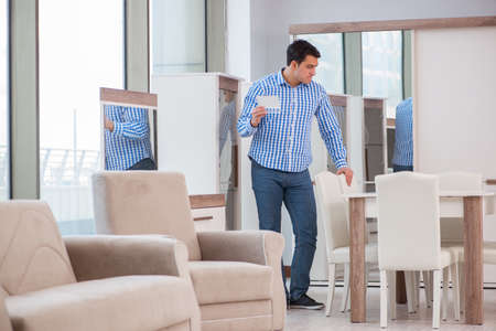 Young man shopping in furniture storeの写真素材