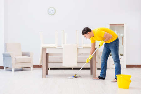 Young man doing chores at homeの写真素材