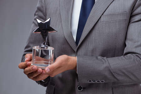Businessman holding star award in business conceptの写真素材