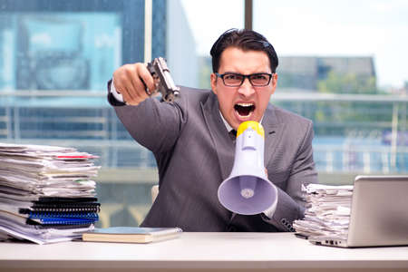 Angry businessman with gun in the officeの写真素材