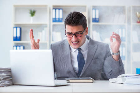 Businessman smoking in office at workの写真素材