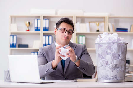 Businessman in paper recycling concept in officeの写真素材