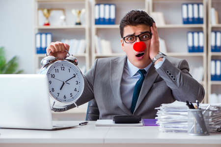 Clown businessman with alarm clock missing dieadlineの写真素材