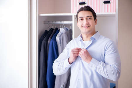Young man businessman getting dressed for workの写真素材
