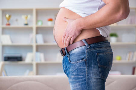 Man suffering from extra weight in diet conceptの写真素材