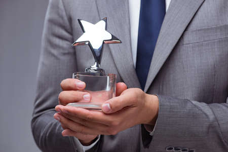 Businessman holding star award in business conceptの写真素材