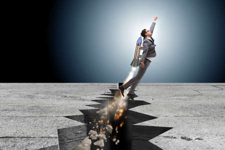Businessman flying on rocket from rock gapの写真素材
