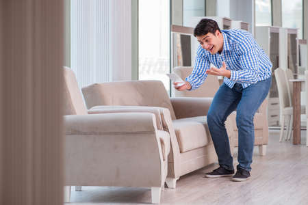 Young man shopping in furniture storeの写真素材