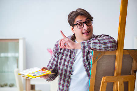 Young male artist drawing pictures in studioの写真素材