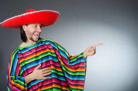 Man in a vivid mexican poncho gray background isolatedの写真素材