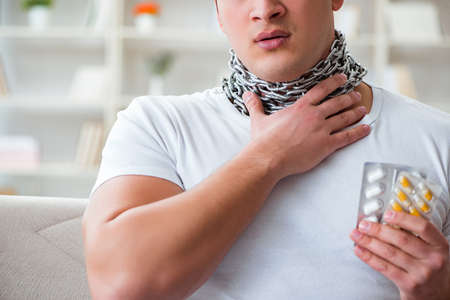 Young man suffering from sore throatの写真素材
