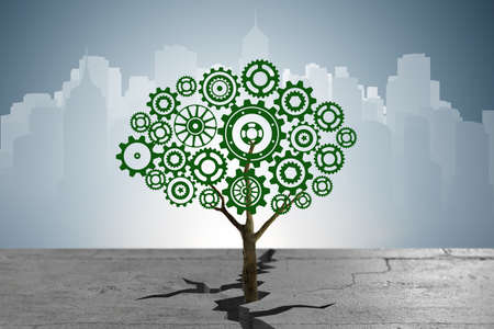 Cogwheel tree growing through soil crackの写真素材