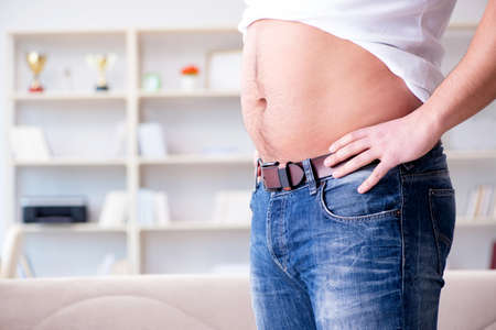 Man suffering from extra weight in diet conceptの写真素材