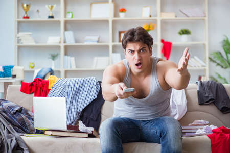 Young man working studying in messy roomの写真素材