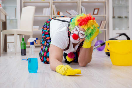 Funny clown doing cleaning at homeの写真素材