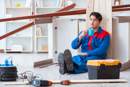 Young carpenter taking break from working with wooden planksの写真素材