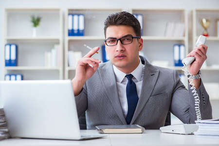 Businessman smoking in office at workの写真素材
