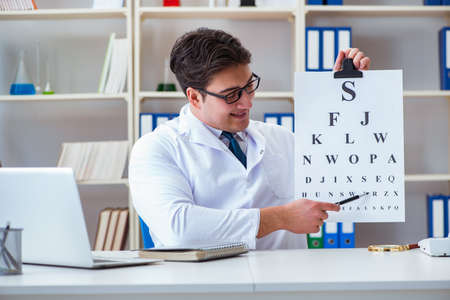 Doctor optician with letter chart conducting an eye test checkの写真素材