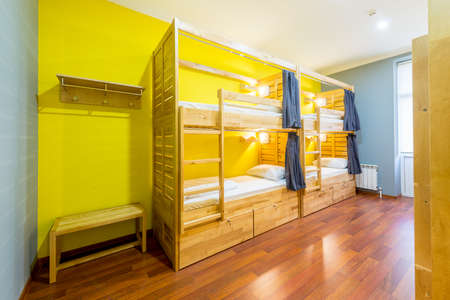 Hostel dormitory beds arranged in roomの写真素材