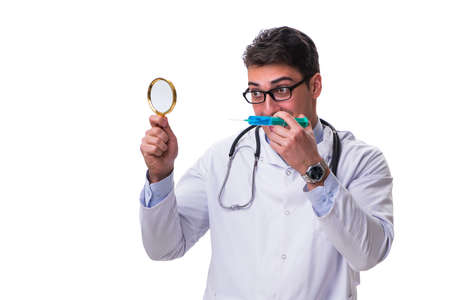 Young doctor with a magnifying glass and a syringe isolated on white backgroundの写真素材