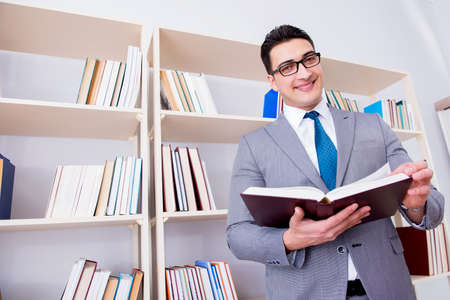 Businessman student reading a book studying in libraryの写真素材