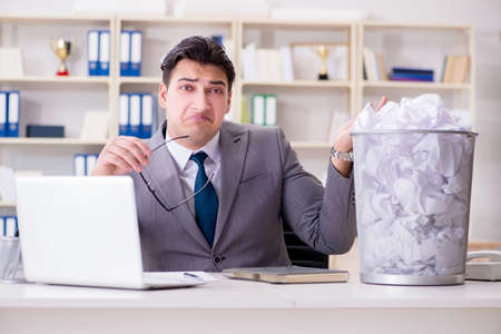 Businessman in paper recycling concept in officeの写真素材