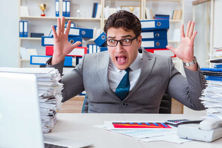 Businessman busy with much paperworkの写真素材