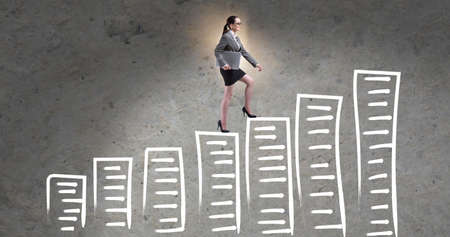 Businesswoman climbing career ladder in business conceptの写真素材