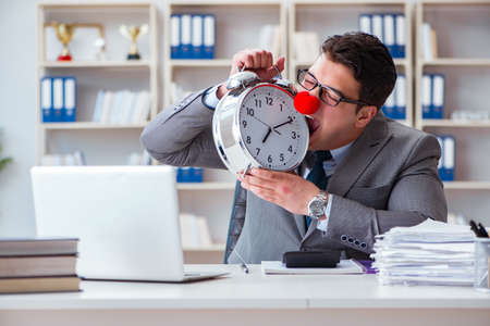 Clown businessman with alarm clock missing dieadlineの写真素材