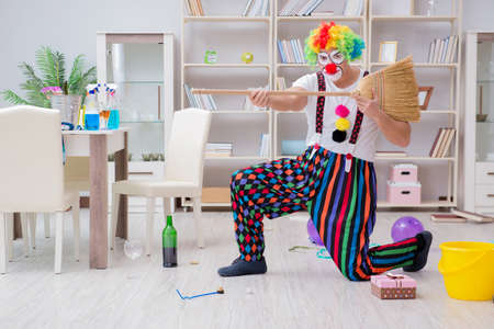 Funny clown doing cleaning at homeの写真素材