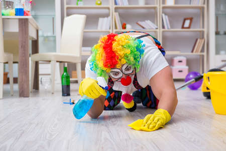 Funny clown doing cleaning at homeの写真素材