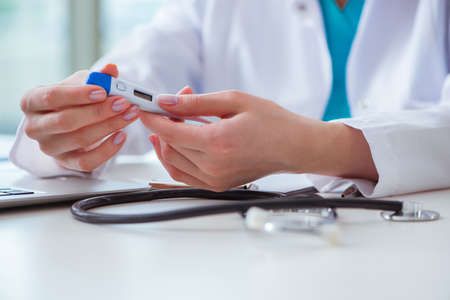 Doctor hand holding temperature thermometerの写真素材