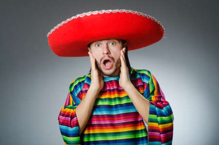 Man in a vivid mexican poncho gray background isolatedの写真素材
