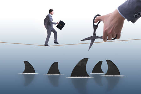 Hand cutting rope in business risk conceptの写真素材