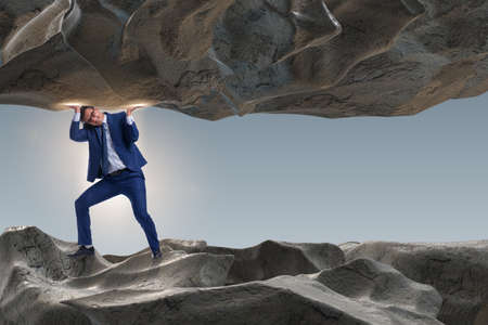 Businessman supporting stone under pressureの写真素材