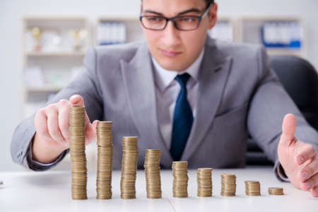 Businessman with golden coins in business growth conceptの写真素材