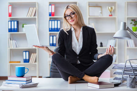 Businesswoman frustrated meditating in the officeの写真素材