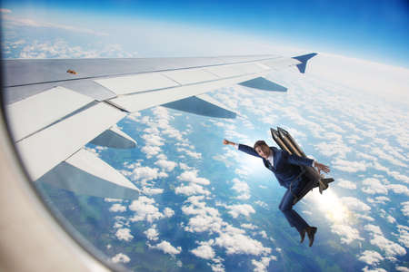 Businessman flying next to commercial flightの写真素材