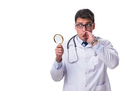 Young male doctor with a looking magnifying glass isolated on whの写真素材