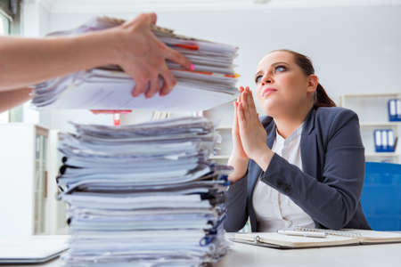 Tired businesswoman with paperwork workload