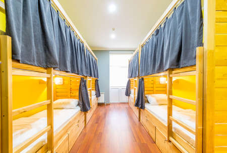Hostel dormitory beds arranged in roomの写真素材