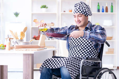 Disabled young husband frying at kitchenの写真素材
