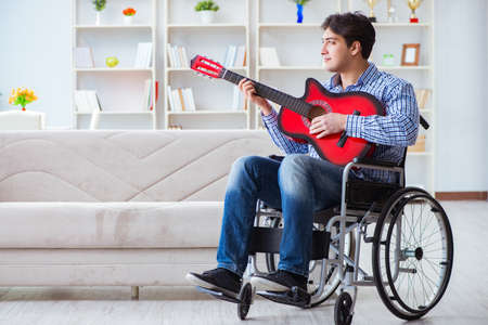 Disabled man playing guitar at homeの写真素材