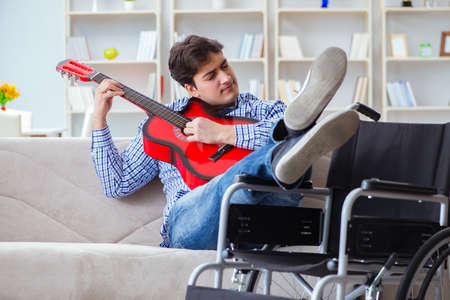 Disabled man playing guitar at homeの写真素材