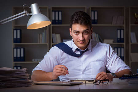 Businessman staying late in office for drugsの写真素材