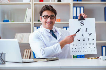 Doctor optician with letter chart conducting an eye test checkの写真素材