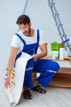 Repairman doing renovation repair in the house with paper wallpaの写真素材