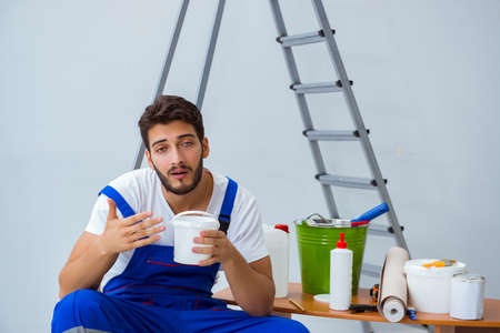 Repairman doing renovation repair in the house with paper wallpaの写真素材