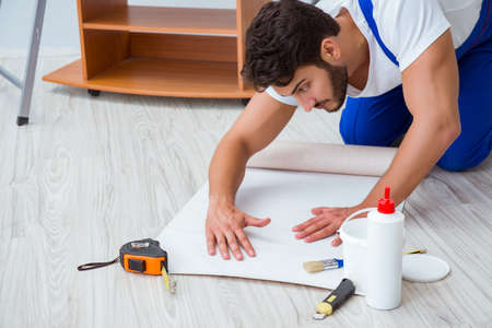 Repairman doing renovation repair in the house with paper wallpaの写真素材