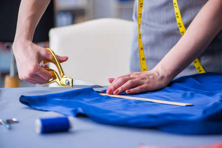Woman tailor working on a clothing sewing stitching measuring faの写真素材